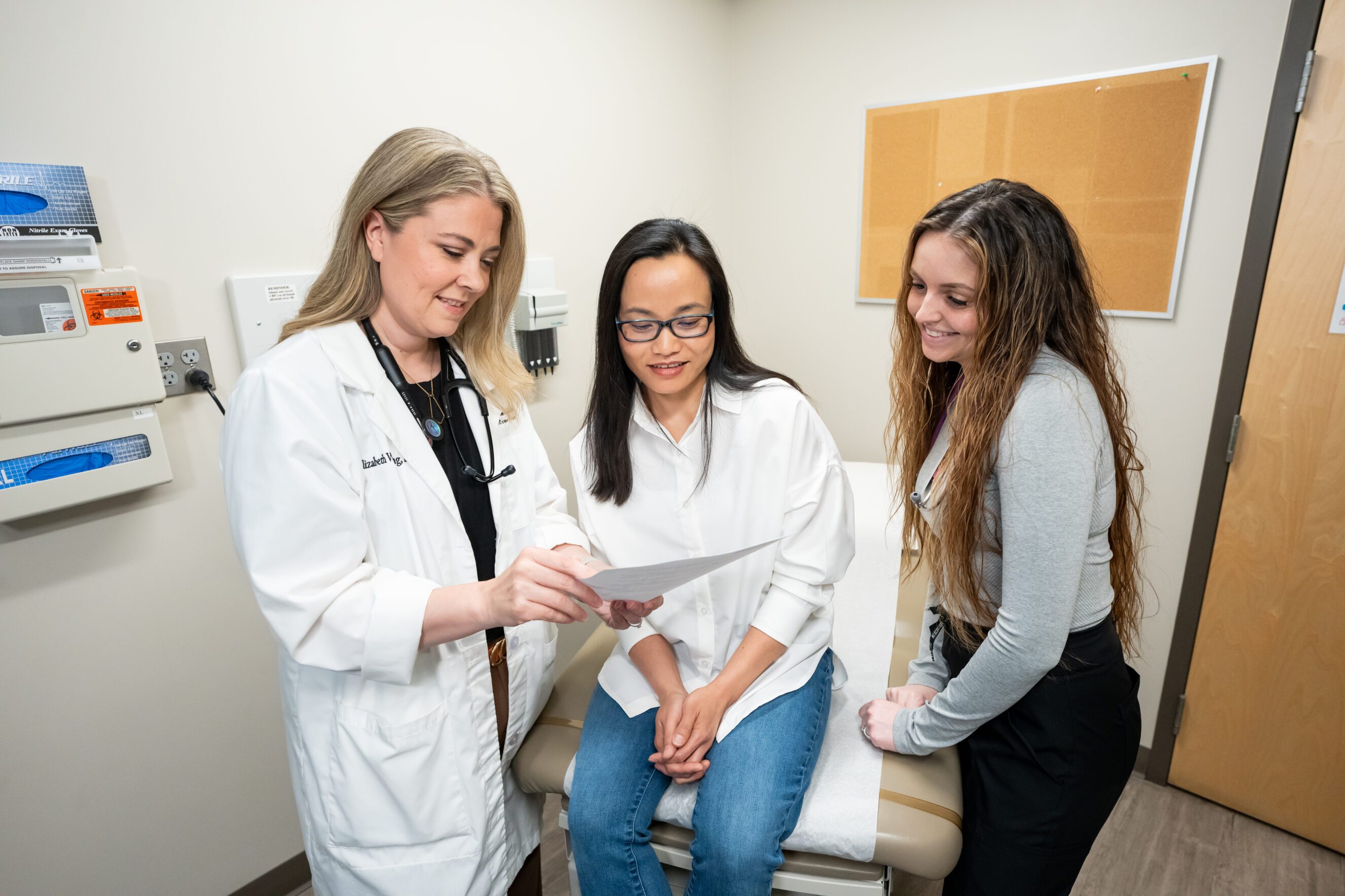 Blonde woman with middle-aged doctor holding her wrist in a splint. Blonde woman with middle-aged doctor holding her wrist in a splint.